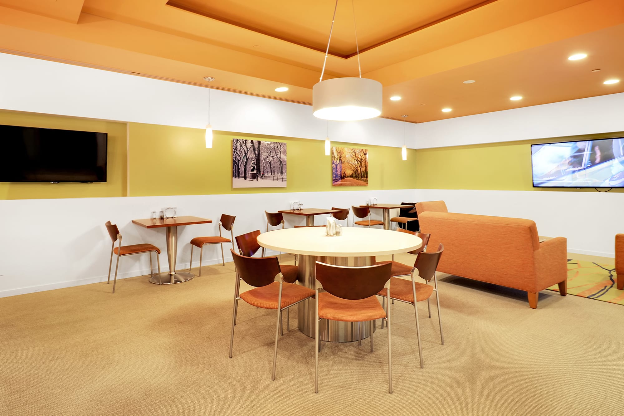 Cafe area with array of seating and a TV at Carr Workplaces Central Park